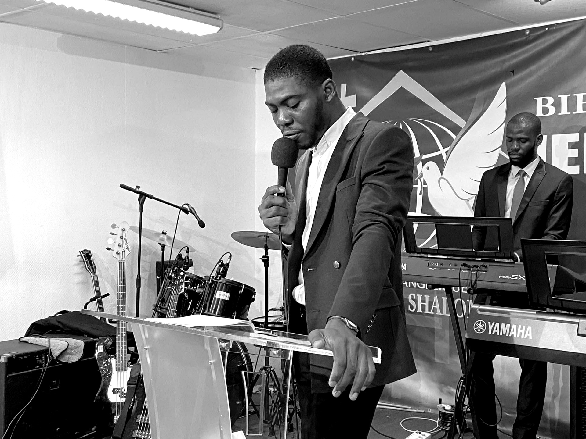 Kalenga 1er micro en main conduisant la louange à l'église, noir et blanc