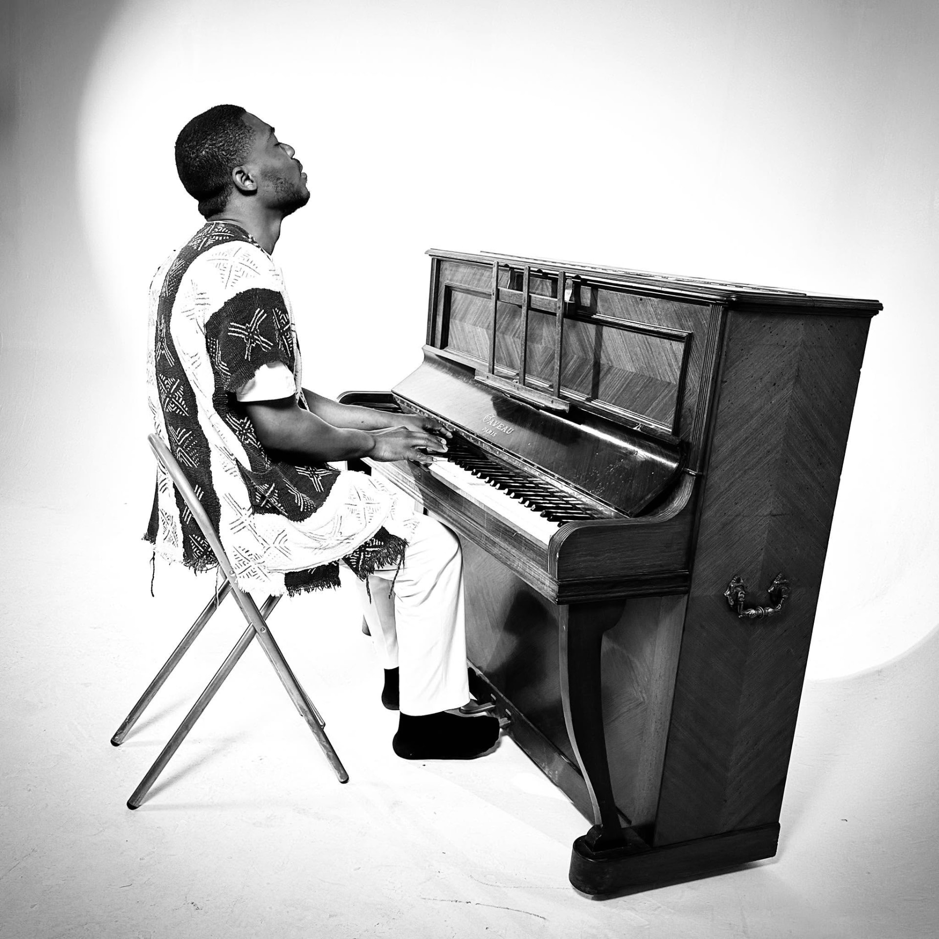 Kalenga 1er au piano, portrait noir et blanc en studio